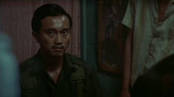 Movie still from “The Year of Living Dangerously” (1982), directed by Peter Weir – A person wearing a military uniform; Close Up shot, High angle