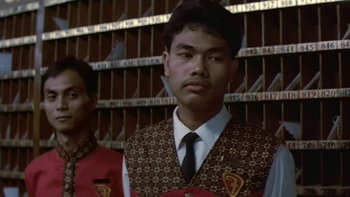 Movie still from “The Year of Living Dangerously” (1982), directed by Peter Weir – A man in a suit and tie standing next to another man in a suit and tie; Close Up shot, Low angle