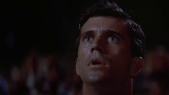 Movie still from “The Year of Living Dangerously” (1982), directed by Peter Weir – A person looking up at the sky; Close Up shot, Low angle