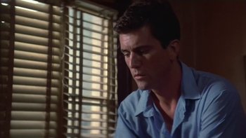 Movie still from “The Year of Living Dangerously” (1982), directed by Peter Weir – A person sitting in front of a window; Close Up shot, Low angle