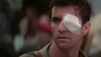 Movie still from “The Year of Living Dangerously” (1982), directed by Peter Weir – A person with a bandage on his eye; Close Up shot, Low angle