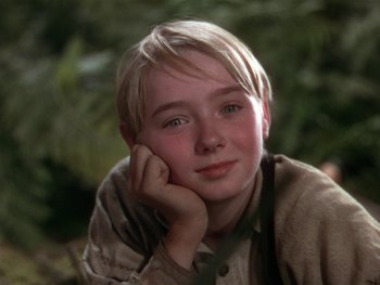 Movie still from “The Yearling” (1946), directed by Clarence Brown – A young boy with blond hair and blue eyes is posing for a picture; Close Up shot, Low angle