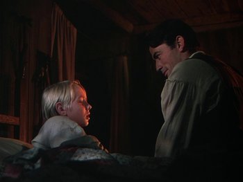 Movie still from “The Yearling” (1946), directed by Clarence Brown – A man and a child in a dark room; Medium shot, Over the shoulder angle