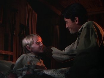 Movie still from “The Yearling” (1946), directed by Clarence Brown – A man and a boy are smiling at each other; Medium shot, Over the shoulder angle