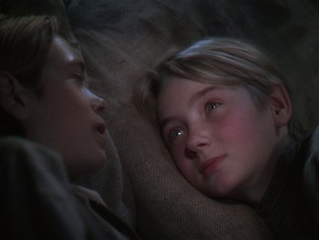 Movie still from “The Yearling” (1946), directed by Clarence Brown – Two people laying on the ground looking at each other; Close Up shot, High angle