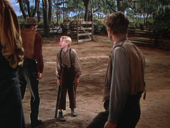 Movie still from “The Yearling” (1946), directed by Clarence Brown – A group of people standing around in the dirt; Wide shot, Over the shoulder angle