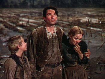 Movie still from “The Yearling” (1946), directed by Clarence Brown – A man and two women standing next to each other; Medium shot, Low angle