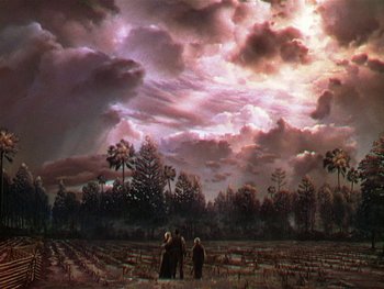 Movie still from “The Yearling” (1946), directed by Clarence Brown – Two people standing in the middle of a field under a cloudy sky; Extreme Wide shot, Low angle