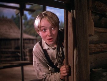 Movie still from “The Yearling” (1946), directed by Clarence Brown – A young man is peeking out of a window; Close Up shot, Low angle