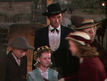 Movie still from “The Yearling” (1946), directed by Clarence Brown – A group of people wearing hats and a suit; Medium shot, Over the shoulder angle