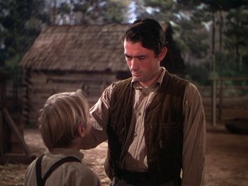 Movie still from “The Yearling” (1946), directed by Clarence Brown – A man and a boy are standing in front of each other; Medium shot, Low angle