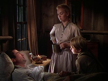 Movie still from “The Yearling” (1946), directed by Clarence Brown – A man and a woman and a boy in a bed; Medium shot, Low angle