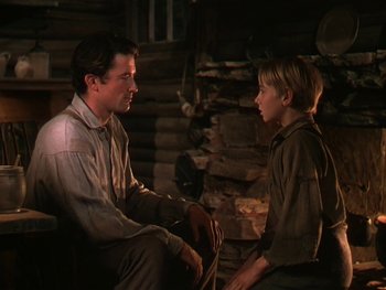 Movie still from “The Yearling” (1946), directed by Clarence Brown – A man and a young boy sitting next to each other; Medium shot, Over the shoulder angle