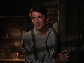 Movie still from “The Yearling” (1946), directed by Clarence Brown – A man in a white shirt and brown suspenders standing next to a door; Close Up shot, Low angle