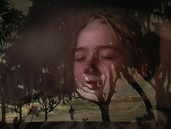Movie still from “The Yearling” (1946), directed by Clarence Brown – A double exposure of a girl and a tree; Close Up shot, Low angle