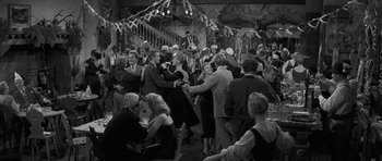 Movie still from “The Young Lions” (1958), directed by Edward Dmytryk – A black and white photo of people dancing at a party; Wide shot, High angle