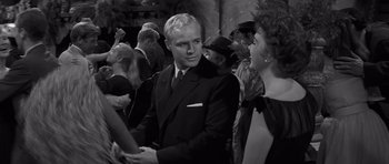 Movie still from “The Young Lions” (1958), directed by Edward Dmytryk – A black and white photo of a man and a woman; Medium shot, Over the shoulder angle