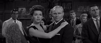 Movie still from “The Young Lions” (1958), directed by Edward Dmytryk – A man and a woman posing for a picture in black and white; Medium shot, Low angle