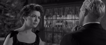 Movie still from “The Young Lions” (1958), directed by Edward Dmytryk – An old black and white photo of a woman looking at a man; Close Up shot, Over the shoulder angle