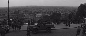 Movie still from “The Young Lions” (1958), directed by Edward Dmytryk – An old photo of some people in a jeep; Extreme Wide shot, High angle