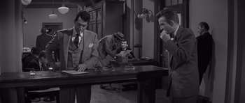 Movie still from “The Young Lions” (1958), directed by Edward Dmytryk – A group of men sitting around a table; Medium shot, Over the shoulder angle