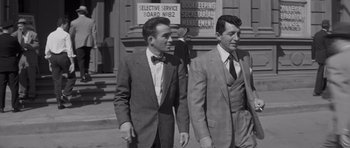 Movie still from “The Young Lions” (1958), directed by Edward Dmytryk – A black and white photo of two men in suits; Medium shot, Over the shoulder angle