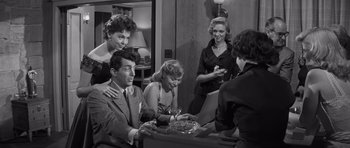 Movie still from “The Young Lions” (1958), directed by Edward Dmytryk – A group of people sitting around a table; Medium shot, Over the shoulder angle