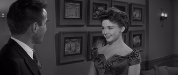 Movie still from “The Young Lions” (1958), directed by Edward Dmytryk – A black and white photo of a woman in a dress; Close Up shot, Over the shoulder angle