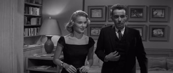 Movie still from “The Young Lions” (1958), directed by Edward Dmytryk – A man and a woman standing next to each other in a room; Medium shot, Low angle