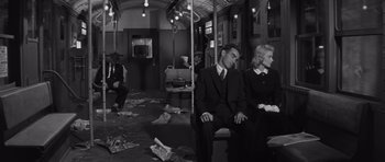 Movie still from “The Young Lions” (1958), directed by Edward Dmytryk – A group of people sitting on a subway train; Wide shot, High angle