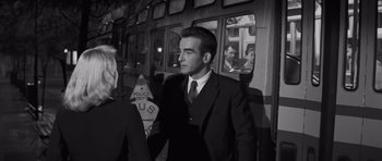 Movie still from “The Young Lions” (1958), directed by Edward Dmytryk – A black and white photo of a man in a suit and tie; Medium shot, Over the shoulder angle