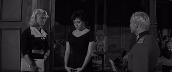 Movie still from “The Young Lions” (1958), directed by Edward Dmytryk – A black and white photo of a woman holding a cell phone; Medium shot, Low angle