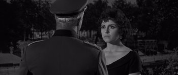 Movie still from “The Young Lions” (1958), directed by Edward Dmytryk – A woman in a military uniform standing next to a man in a uniform; Close Up shot, Over the shoulder angle