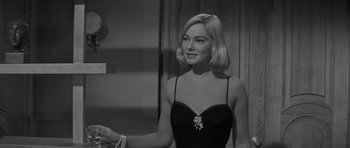 Movie still from “The Young Lions” (1958), directed by Edward Dmytryk – A black and white photo of a woman in a black dress; Close Up shot, Over the shoulder angle