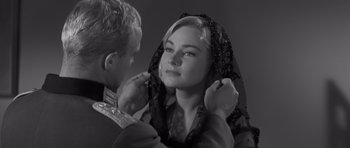 Movie still from “The Young Lions” (1958), directed by Edward Dmytryk – A man putting a veil on a woman's face; Close Up shot, Over the shoulder angle