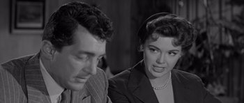 Movie still from “The Young Lions” (1958), directed by Edward Dmytryk – A man and a woman sitting next to each other in a room; Close Up shot, Over the shoulder angle