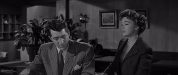 Movie still from “The Young Lions” (1958), directed by Edward Dmytryk – A man and a woman standing next to each other in a room; Medium shot, Over the shoulder angle