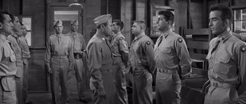 Movie still from “The Young Lions” (1958), directed by Edward Dmytryk – A black and white photo of a group of men in uniform; Medium shot, Low angle