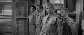 Movie still from “The Young Lions” (1958), directed by Edward Dmytryk – A black and white photo of three men in uniform; Medium shot, Low angle