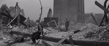 Movie still from “The Young Lions” (1958), directed by Edward Dmytryk – Two men are standing in the ruins of a building; Wide shot, Low angle