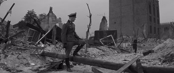 Movie still from “The Young Lions” (1958), directed by Edward Dmytryk – An old photo of a man in a military uniform; Wide shot, Low angle
