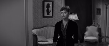 Movie still from “The Young Lions” (1958), directed by Edward Dmytryk – A black and white photo of a woman in a living room; Medium shot, Over the shoulder angle