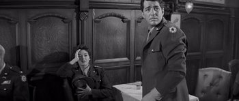 Movie still from “The Young Lions” (1958), directed by Edward Dmytryk – A man and a woman sitting in front of a table; Medium shot, Over the shoulder angle