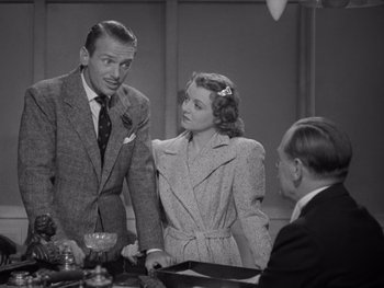 Movie still from “The Young in Heart” (1938), directed by Gilbert Pratt – A man and a woman standing next to each other in front of another man; Medium shot, Over the shoulder angle