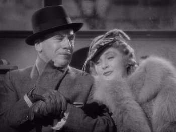 Movie still from “The Young in Heart” (1938), directed by Gilbert Pratt – A man and a woman are standing next to each other; Close Up shot, Low angle