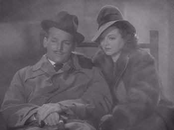 Movie still from “The Young in Heart” (1938), directed by Gilbert Pratt – An old black and white photo of a man and a woman; Medium shot, High angle