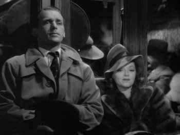 Movie still from “The Young in Heart” (1938), directed by Gilbert Pratt – A man and a woman sitting on a train; Medium shot, Low angle