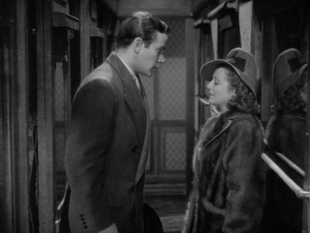 Movie still from “The Young in Heart” (1938), directed by Gilbert Pratt – A man and a woman standing next to each other; Medium shot, High angle