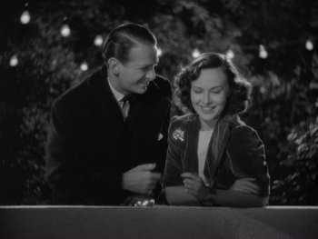 Movie still from “The Young in Heart” (1938), directed by Gilbert Pratt – A man and a woman smiling at each other; Medium shot, High angle