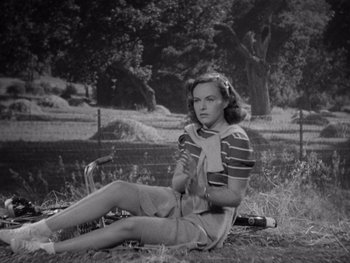 Movie still from “The Young in Heart” (1938), directed by Gilbert Pratt – A woman sitting on the ground in a field; Medium shot, High angle